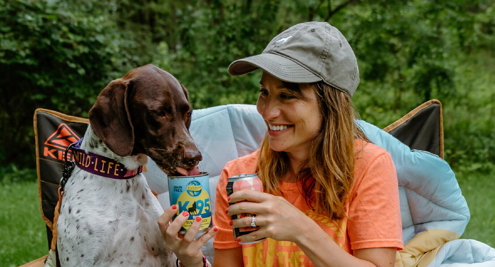 A person holds a can while feeding a dog canned wet food