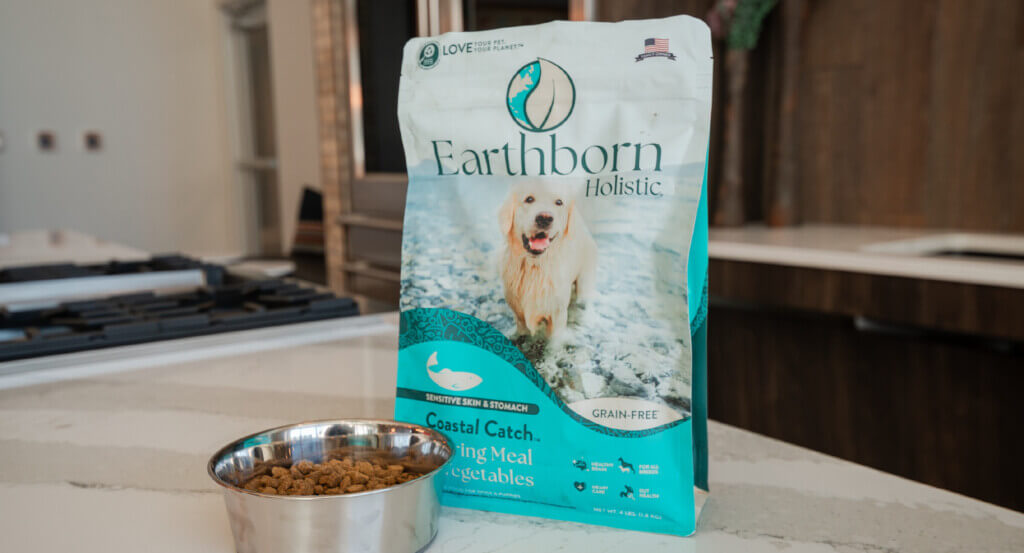 Bag of Coastal Catch sits next to bowl of dog food on counter