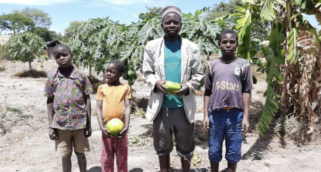 Hamis and three of his children stand in their forest garden