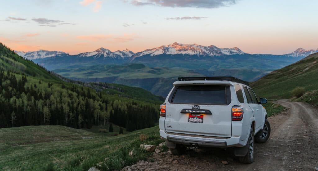 An image of a 4 Runner parked at an outlook point of a mountain range