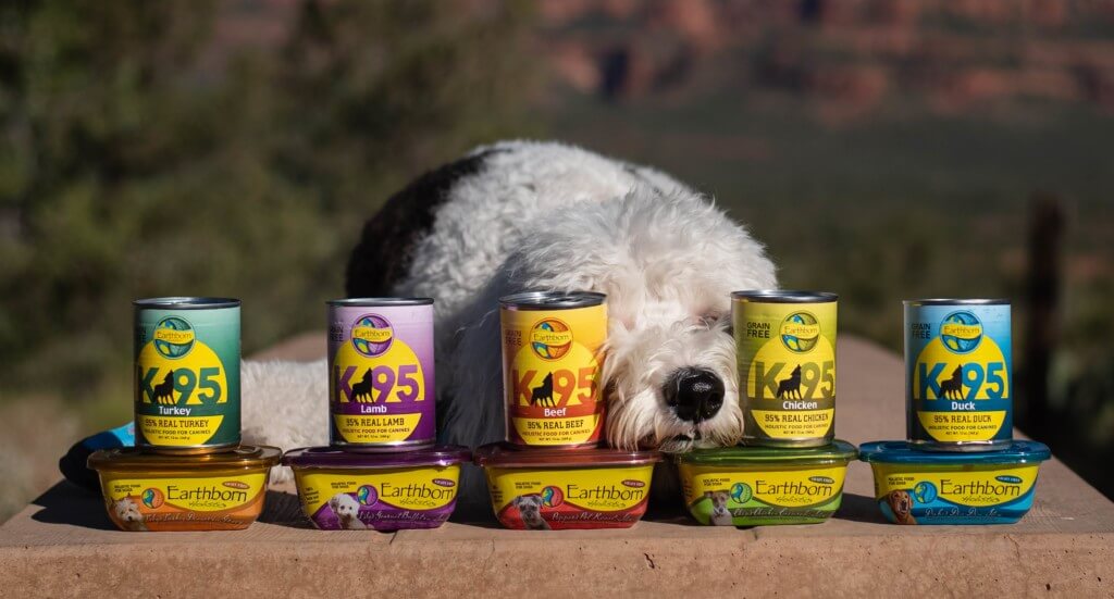 A dog puts his nose between a variety of wet dog food recipes