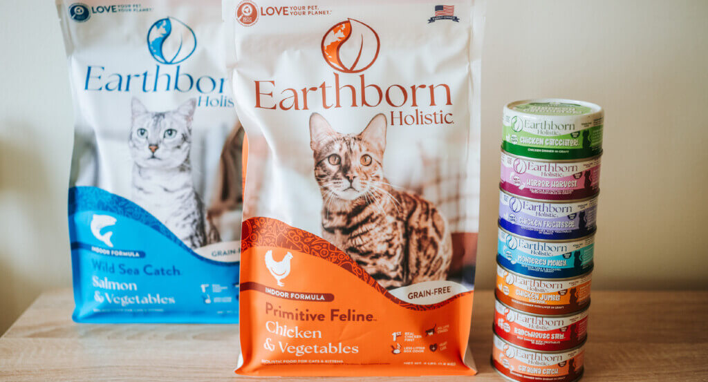 2 bags of cat food sit next to stack of cat cans