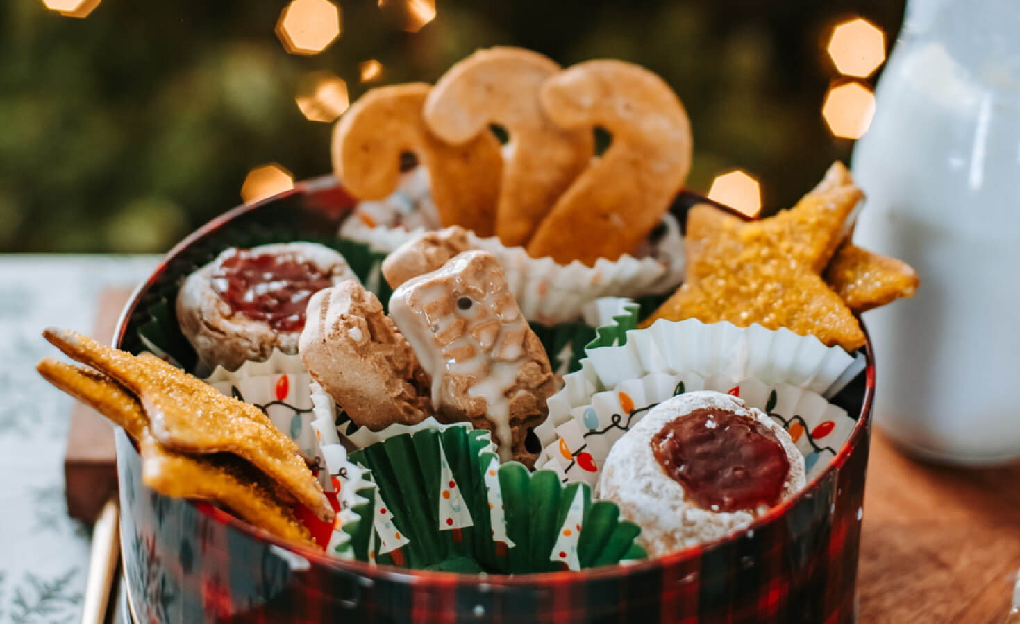 container of Christmas theme dog treats sits on table