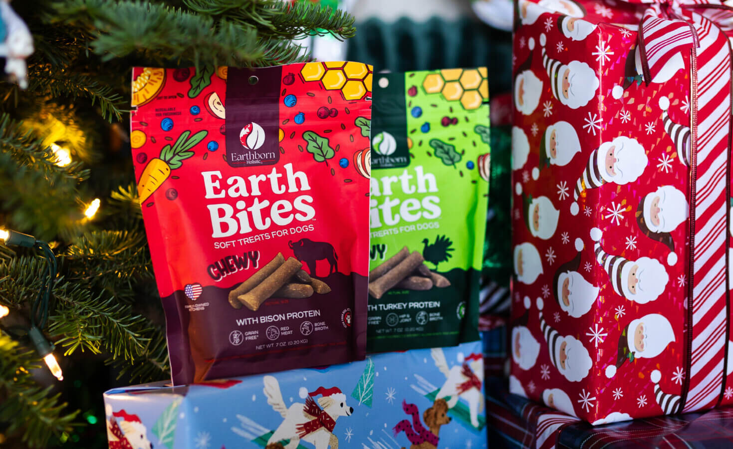 Two bags of EarthBites sit on presents in front of Christmas Tree