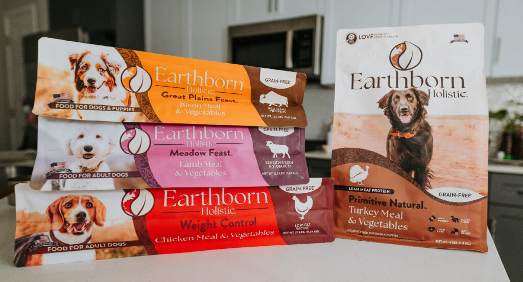 A variety of Earthborn Holistic dog food sits on counter