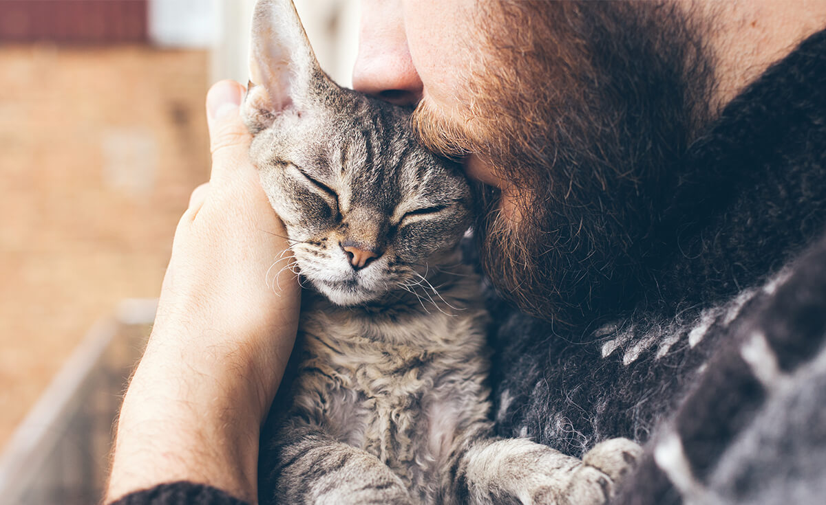 man cuddling with his cat