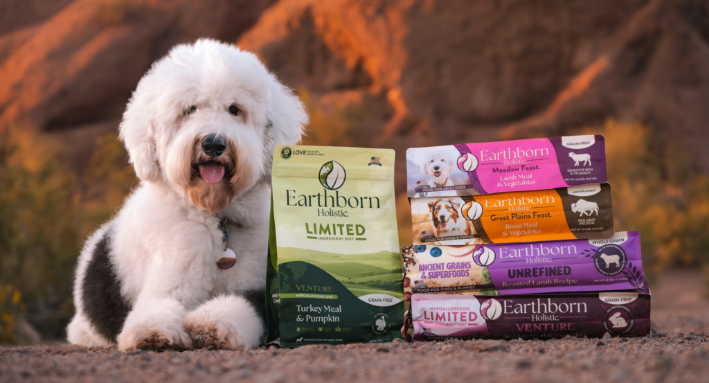dog sitting with Earthborn. holistic ancient grain dog food
